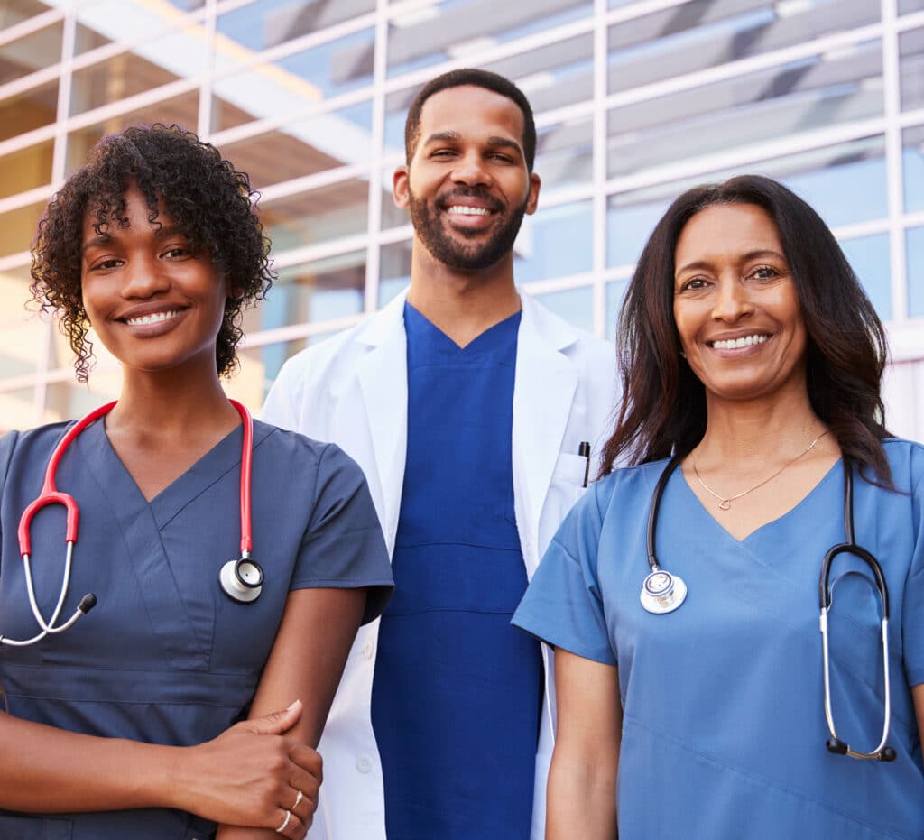 Three healthcare colleagues standing outside modern hospital